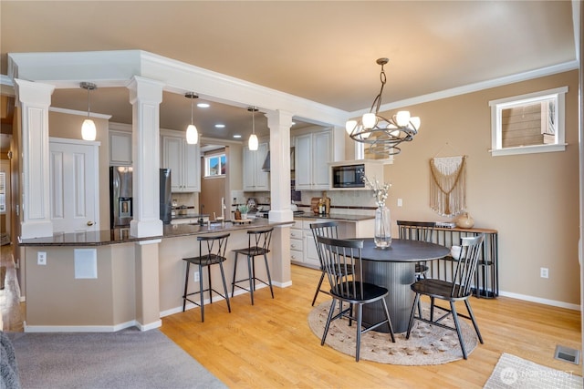 3212 Maplewood Cir NE, Tacoma, WA 98422 - dining area featuring decorative columns, light wood finished floors, and ornamental molding