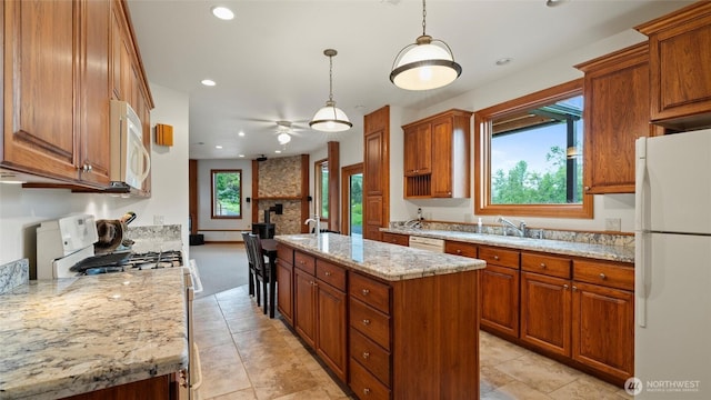 kitchen featuring white appliances, ceiling fan, a center island with sink, brown cabinets, and recessed lighting