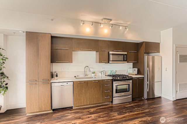 2911 2nd Ave Unit 513, Seattle, WA 98121 - kitchen with stainless steel appliances, a sink, light countertops, dark wood-style floors, and baseboards