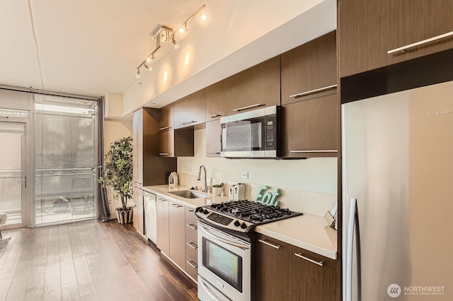2911 2nd Ave Unit 513, Seattle, WA 98121 - kitchen featuring stainless steel appliances, a sink, light countertops, and dark wood-style floors