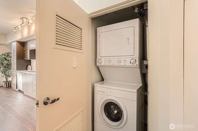 2911 2nd Ave Unit 513, Seattle, WA 98121 - clothes washing area with stacked washer and clothes dryer and wood finished floors