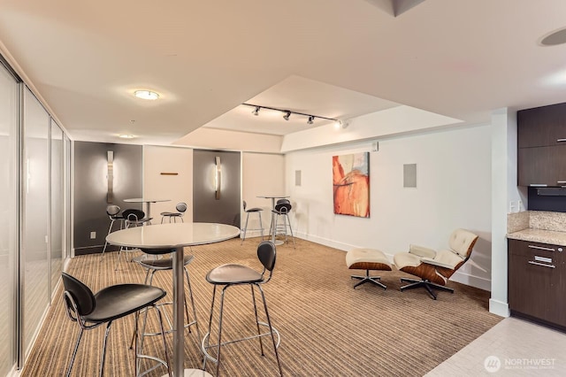 2911 2nd Ave Unit 513, Seattle, WA 98121 - dining space with track lighting, baseboards, and light carpet