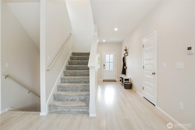 stairway with wood finished floors, recessed lighting, and baseboards