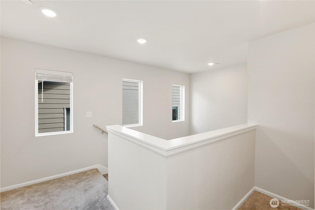 hallway with an upstairs landing, carpet flooring, baseboards, and recessed lighting