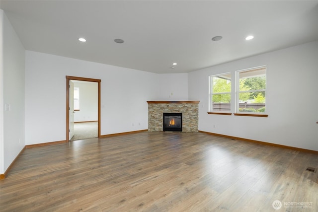 997 Chestnut Loop, Mount Vernon, WA 98273 - unfurnished living room featuring baseboards, wood finished floors, a stone fireplace, and recessed lighting