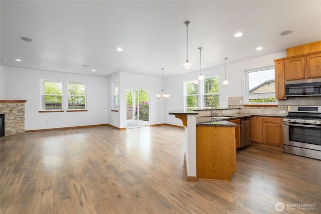 997 Chestnut Loop, Mount Vernon, WA 98273 - kitchen featuring appliances with stainless steel finishes, open floor plan, a peninsula, a chandelier, and a kitchen breakfast bar