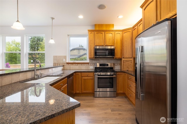 997 Chestnut Loop, Mount Vernon, WA 98273 - kitchen with stainless steel appliances, a sink, tasteful backsplash, brown cabinets, and dark stone countertops