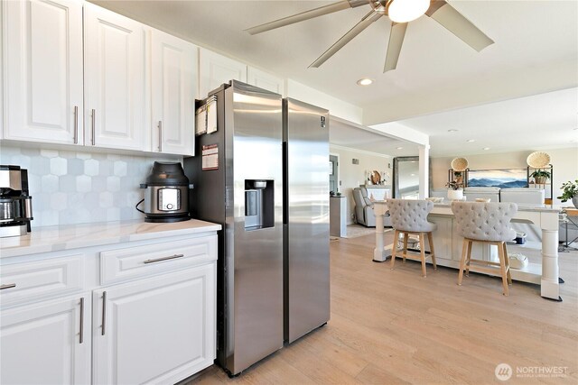 3415 Garden Ave N, Renton, WA 98056 - kitchen featuring stainless steel refrigerator with ice dispenser, light wood-type flooring, decorative backsplash, white cabinets, and a ceiling fan