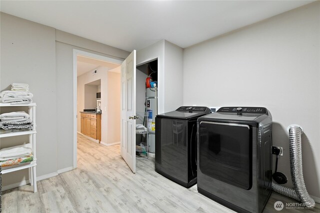 3415 Garden Ave N, Renton, WA 98056 - laundry area with light wood finished floors, washing machine and dryer, and baseboards