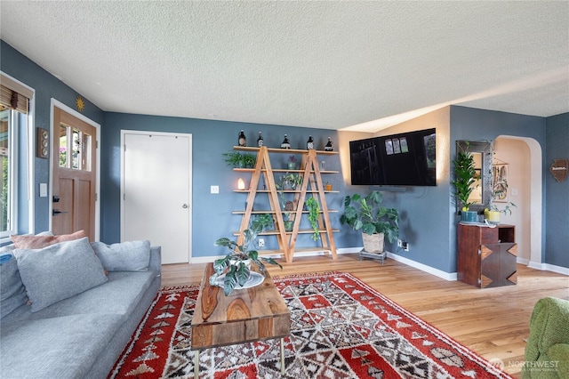 11008 2nd Ave S, Seattle, WA 98168 - living room featuring a textured ceiling, wood finished floors, arched walkways, and baseboards