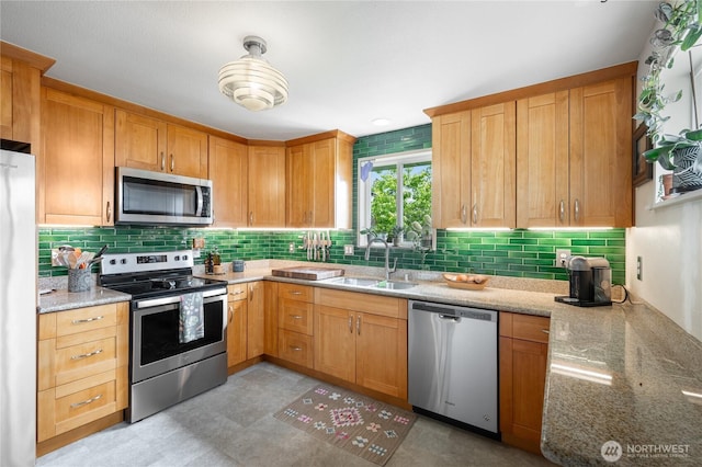 11008 2nd Ave S, Seattle, WA 98168 - kitchen featuring appliances with stainless steel finishes, a sink, light stone counters, and backsplash