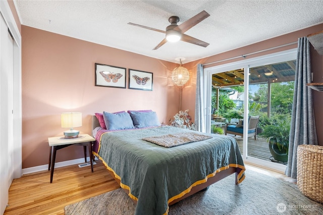 11008 2nd Ave S, Seattle, WA 98168 - bedroom featuring access to exterior, wood finished floors, a textured ceiling, baseboards, and ceiling fan