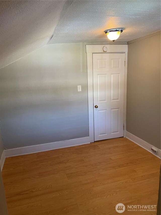 328 S Division St, Auburn, WA 98001 - empty room with a textured ceiling, baseboards, light wood-type flooring, and vaulted ceiling