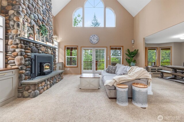 carpeted living room with high vaulted ceiling and french doors