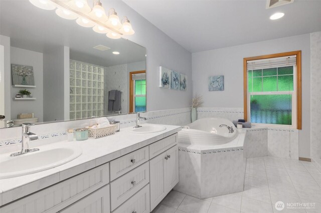 bathroom featuring tile patterned floors, a garden tub, and double vanity