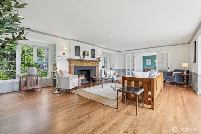 16255 38th Ave NE, Lake Forest Park, WA 98155 - living area featuring light wood-style flooring, french doors, a fireplace, crown molding, and wainscoting