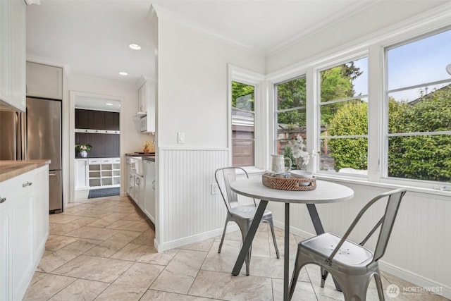 16255 38th Ave NE, Lake Forest Park, WA 98155 - dining room with healthy amount of natural light, wainscoting, ornamental molding, stone tile flooring, and a decorative wall