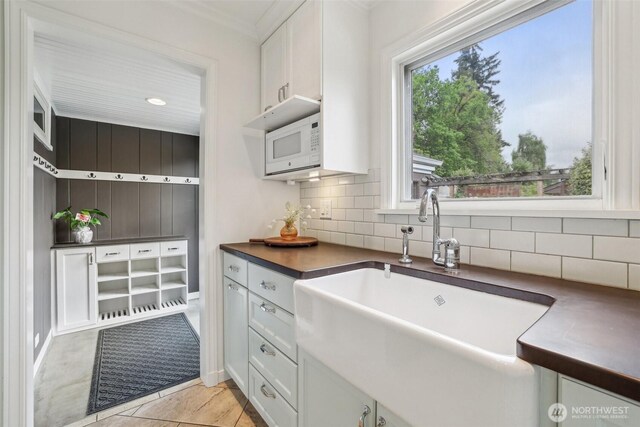 16255 38th Ave NE, Lake Forest Park, WA 98155 - kitchen with dark countertops, a sink, decorative backsplash, white cabinetry, and ornamental molding