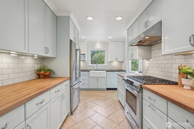 16255 38th Ave NE, Lake Forest Park, WA 98155 - kitchen with appliances with stainless steel finishes, wood counters, under cabinet range hood, a sink, and recessed lighting