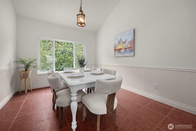 7725 Perregrine Pl, Arlington, WA 98223 - dining space with wainscoting, vaulted ceiling, and dark tile patterned floors