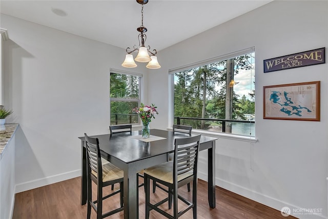 dining room featuring baseboards, wood finished floors, and a chandelier