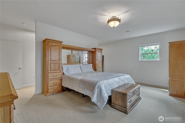 bedroom featuring light colored carpet and baseboards