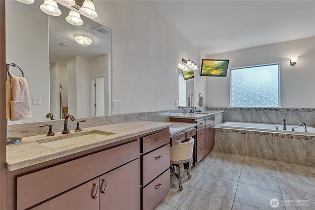 bathroom with a garden tub, vanity, and marble finish floors
