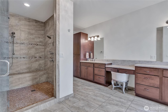 bathroom with a shower stall and vanity