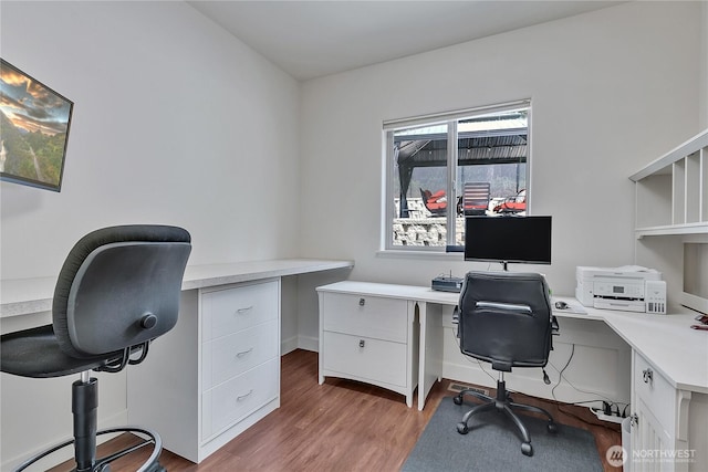 home office featuring built in study area and wood finished floors