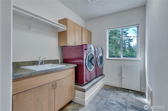 washroom with independent washer and dryer, cabinet space, and baseboards
