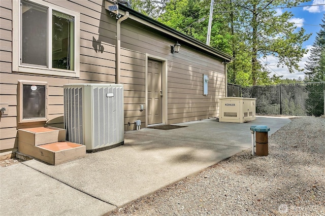 entrance to property with central AC, fence, and a patio