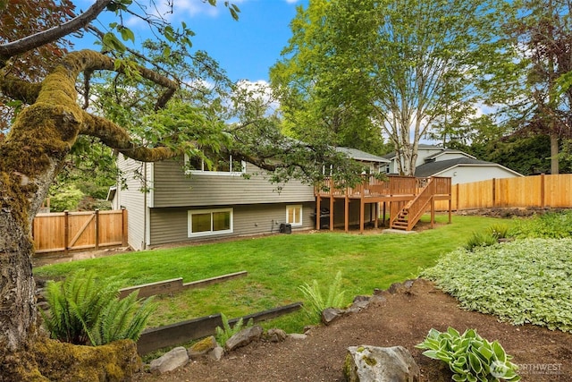 back of property with stairs, a wooden deck, and a garden