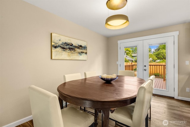 dining area featuring french doors, baseboards, and wood finished floors