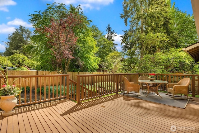 deck with outdoor dining space and fence