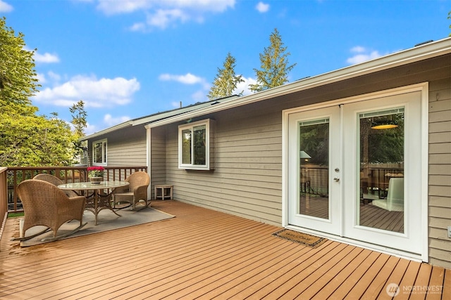 wooden terrace featuring outdoor dining space and french doors