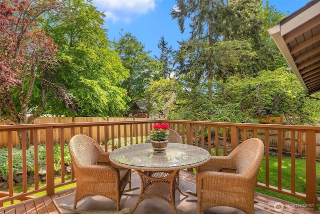 deck with outdoor dining space and a fenced backyard
