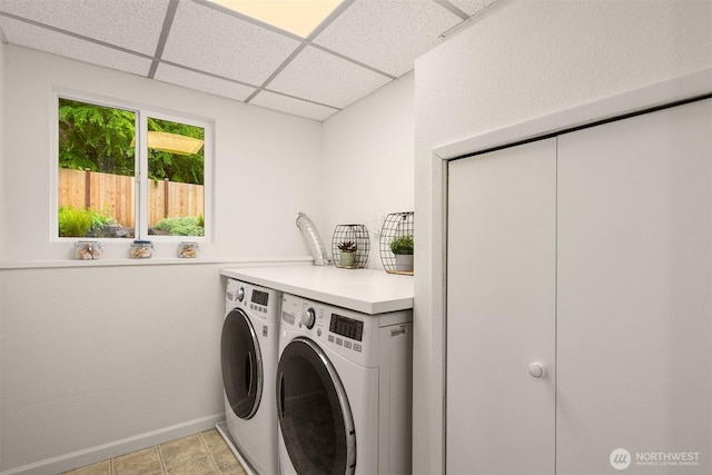 laundry room with washing machine and dryer and baseboards