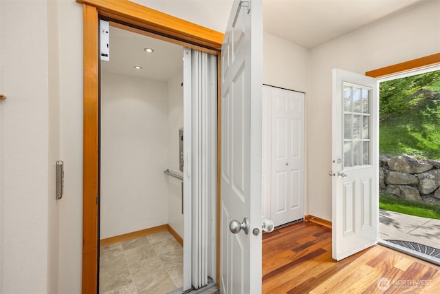 bathroom featuring elevator and baseboards