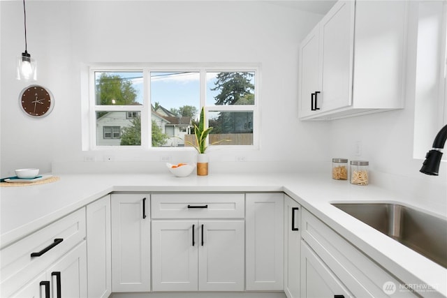 2805 S 11th St, Tacoma, WA 98405 - kitchen with a sink, white cabinets, light countertops, and decorative light fixtures