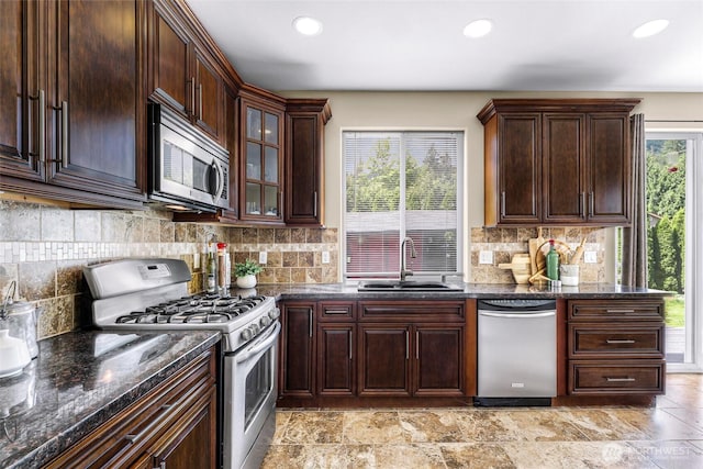 7911 Oregon Trl, Maple Falls, WA 98266 - kitchen with stainless steel appliances, a sink, recessed lighting, dark stone countertops, and decorative backsplash