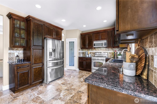 7911 Oregon Trl, Maple Falls, WA 98266 - kitchen featuring appliances with stainless steel finishes, a sink, tasteful backsplash, recessed lighting, and glass insert cabinets