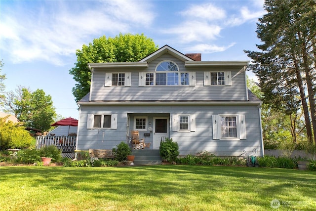 view of front of house with a chimney and a front yard