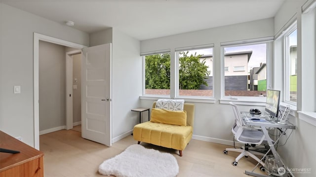 living area with a desk, light wood-style floors, and baseboards