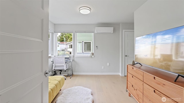 bedroom featuring a wall mounted AC, light wood-style floors, and baseboards