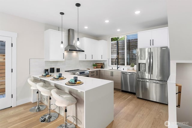 1319 14th Ave S Unit B, Seattle, WA 98144 - kitchen with stainless steel appliances, wall chimney range hood, light wood-type flooring, a sink, and recessed lighting