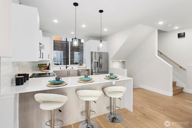 1319 14th Ave S Unit B, Seattle, WA 98144 - kitchen with appliances with stainless steel finishes, a peninsula, light countertops, light wood-style flooring, and a sink