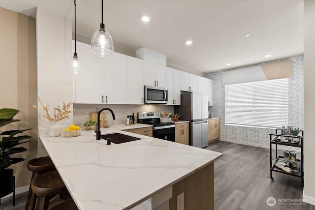 14707 87th Ave SE Unit Ff5, Snohomish, WA 98296 - kitchen featuring appliances with stainless steel finishes, a sink, dark wood-style floors, a peninsula, and a kitchen breakfast bar