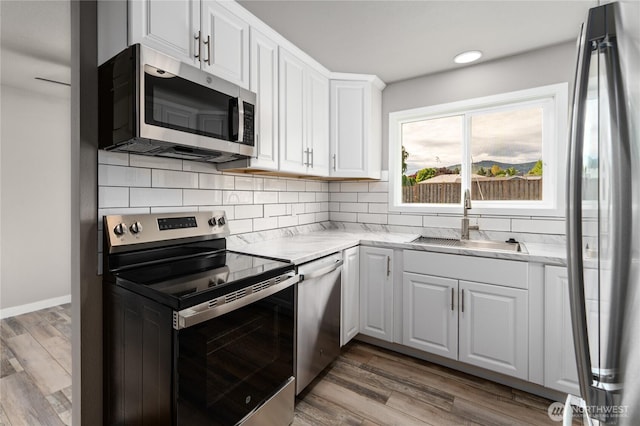 1819 Springwater Ave, Wenatchee, WA 98801 - kitchen with stainless steel appliances, a sink, tasteful backsplash, white cabinetry, and wood finished floors