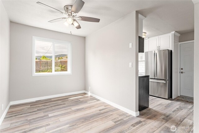 1819 Springwater Ave, Wenatchee, WA 98801 - kitchen featuring freestanding refrigerator, a ceiling fan, white cabinets, light wood-style flooring, and baseboards
