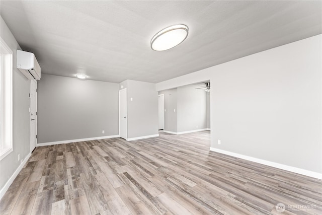 1819 Springwater Ave, Wenatchee, WA 98801 - unfurnished room featuring an AC wall unit, light wood-type flooring, baseboards, and ceiling fan